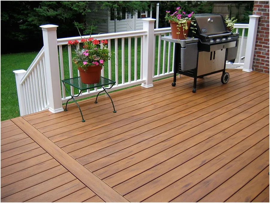 Finished wood deck with white railing and planted containers