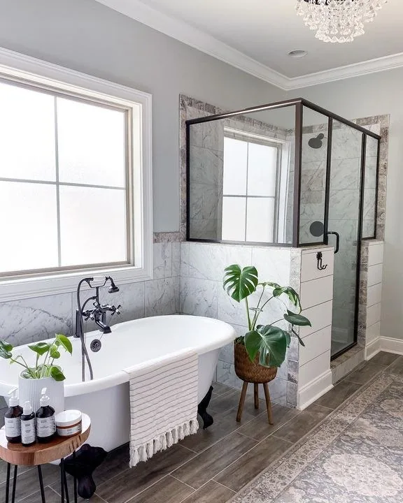 Clawfoot soaking tub and marble tiled shower in a Serenity Contracting bathroom remodel
